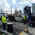 Construction worker inspecting drilling rig.